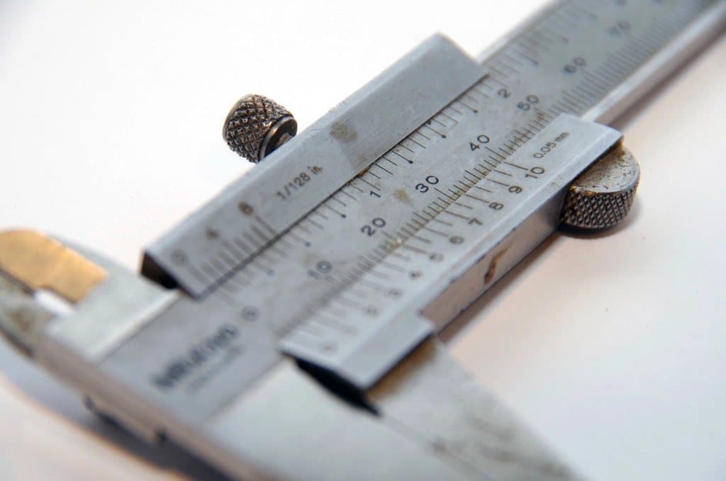 A vernier caliper measuring a component, a traceable dimensional standard
